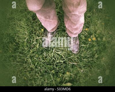 Uomo in piedi in erba indossando scarpe Foto Stock