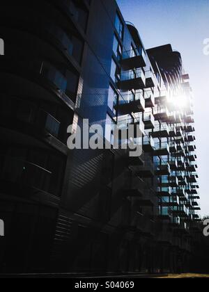 Luminoso nuovo giorno, il sole splende attraverso i balconi di un moderno city apartment block Foto Stock