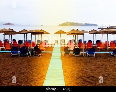 Sedie a sdraio su una spiaggia deserta Foto Stock