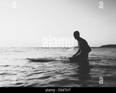 Surfer sulla tavola da surf in attesa di onde. Foto Stock