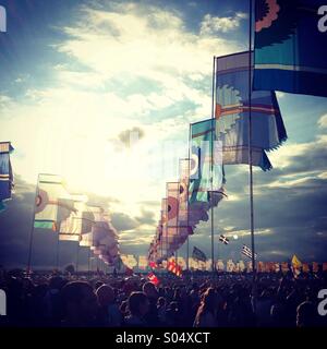 Folla bandiere blu cielo atmosfera festival di Glastonbury 2014 Foto Stock