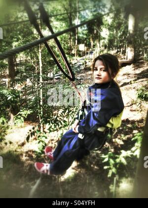 Ragazza giovane tree climbing Foto Stock