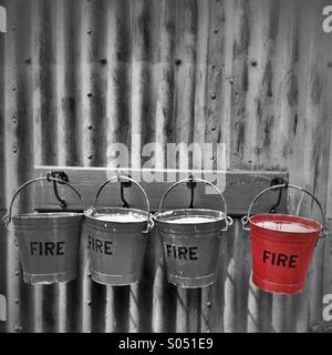 Fire bucket appeso a una parete Foto Stock