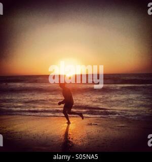 Uomo che corre lungo Scarborough Beach a Perth, Western Australia Foto Stock