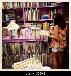 Ragazza asiatica per l'acquisto di un libro Foto Stock