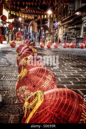 L'uomo prepara le lanterne di carta per appendere su Gerrard Street a Londra in Chinatown Foto Stock