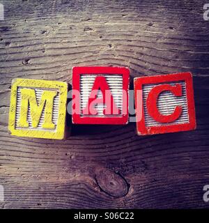 Si tratta di una foto di tavolette di legno giocattolo giochi con alfabeto lettere su di loro che si uniscono per formare la parola MAC Foto Stock
