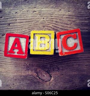 Si tratta di una foto di tavolette di legno giocattolo giochi con alfabeto lettere su di essi che si combinano insieme per formare ABC Foto Stock