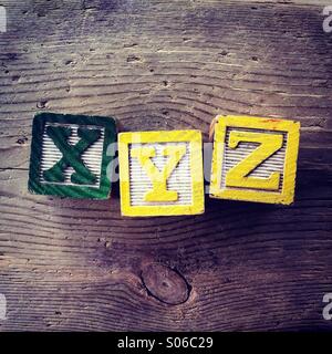 Si tratta di una foto di tavolette di legno giocattolo giochi con alfabeto lettere su di essi che si combinano insieme per formare XYZ Foto Stock