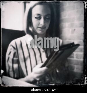 Una giovane donna che utilizza un computer tablet Foto Stock