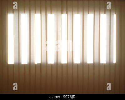 La luce che filtra attraverso le tende della finestra Foto Stock
