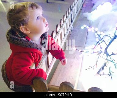 Bambina fissando le luci di Natale in meraviglia