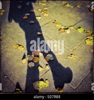 Ombra di un pedone a camminare sulla strada a autumm in Barcellona, in Catalogna, Spagna Foto Stock