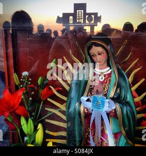 La croce rappresenta il messicano del dio della pioggia Tlaloc riflessa in un vetro a copertura di un immagine di Nostra Signora di Guadalupe durante l'annuale pellegrinaggio alla Basilica di Guadalupe a Città del Messico Foto Stock