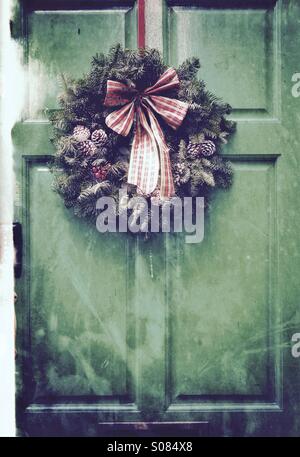 Il Natale porta - una ghirlanda di Natale su una porta verde Foto Stock