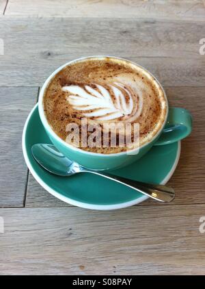 Una tazza di latte con arte sulla sommità di esso Foto Stock