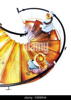 Due bambini scendendo la scala a chiocciola è vista dal di sopra Foto Stock