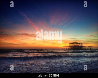 La bruciata rimane di Brighton il Molo Ovest al tramonto, in Brighton, Inghilterra, Regno Unito. Foto Stock