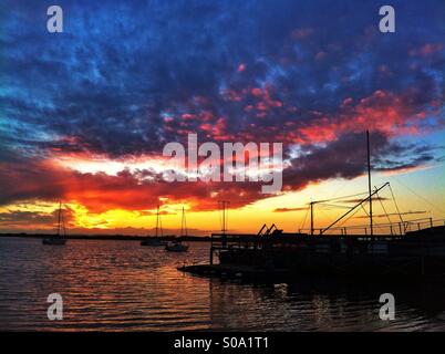 Rosa tramonto sul boat yard jetty Foto Stock