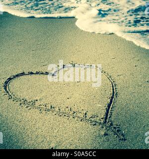 Un cuore disegnato nella sabbia al litorale. Manhattan Beach, California USA. Foto Stock