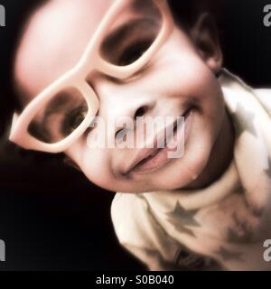 Little Boy in bicchieri con dribbling. Foto Stock