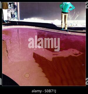 Un negativo di un ombra sul fondo di una piscina di una persona che si tuffano da un trampolino. Foto Stock