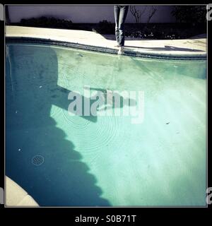 Un ombra sul fondo di una piscina di una persona che si tuffano da un trampolino. Foto Stock