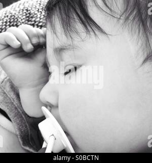 Piccola bambina dormire con succhietto in bianco e nero Foto Stock