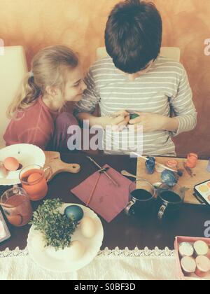 Fratello e Sorella di pittura delle uova di Pasqua in casa Foto Stock