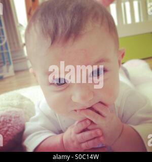 Baby mangiare le sue dita Foto Stock