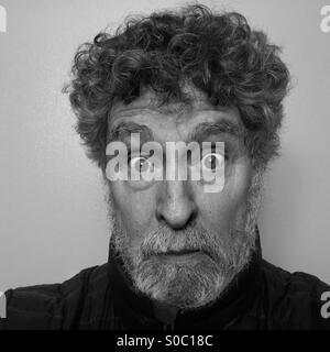 Uomo caucasico, 64 anni, con espressione vuota e ingrigimento barba, close-up Foto Stock