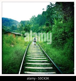 Schoolgirl passeggiate lungo binari del treno vicino a Ella in Sri Lanka Foto Stock