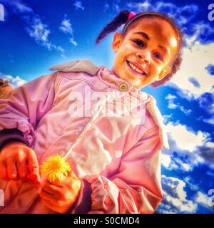 Bambina tenendo un dente di leone Foto Stock