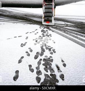 In arrivo in un aeroporto appena caduto durante la notte la neve. Orme di lasciare l'aereo Foto Stock