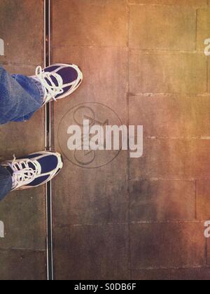 Mans piedi dal lato di un segno di ciclismo Foto Stock