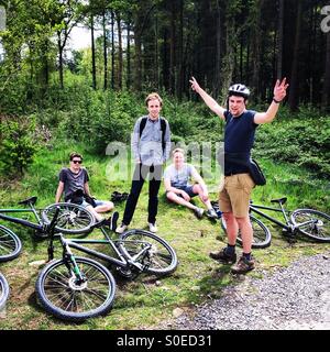 Mountain bike nella Foresta di Dean - quattro uomini avente un buon tempo all'aperto. Foto Stock