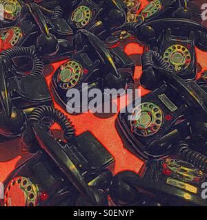 Un colorato astratto illustrazione digitale di molti giocattoli telefoni rotante su una superficie di colore rosso Foto Stock