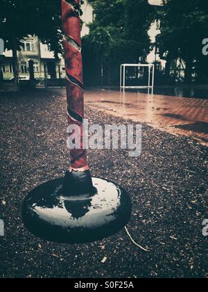 Un parco giochi deserte sotto la pioggia Foto Stock