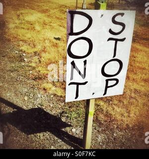 Una scritta a mano segno lungo la strada è stampato in grassetto con le parole dont stop. Foto Stock