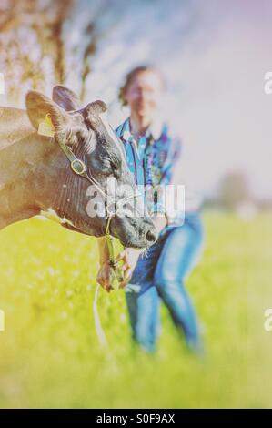 Cowgirl e vacca in campagna Foto Stock