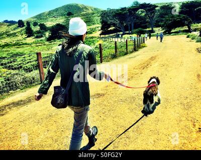 Passeggiate con il cane su un soleggiato vibrant blue sky giorno lungo i sentieri costieri in Pacifica, California, Stati Uniti d'America. Foto Stock