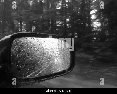 Specchio auto sotto la pioggia. Foto Stock