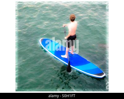 Guardando verso il basso in corrispondenza di un uomo su uno Stand Up Paddle Board (SUP) a Santa Barbara in California Foto Stock