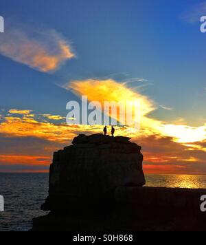 Due uomini su un pulpito rock Portland bill al tramonto Foto Stock