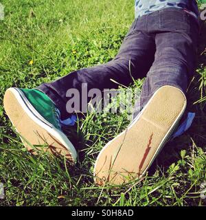 Ragazzo giovane giacente in erba Foto Stock