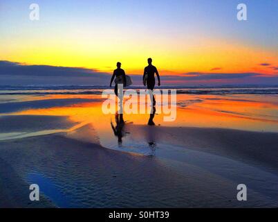 I surfisti al tramonto Foto Stock