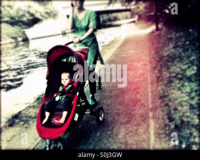 Bambino in buggy lungo il Grand Union Canal, Greenford, London Borough of Ealing, West London, England, Regno Unito, Europa Foto Stock