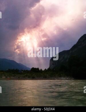 Raggi di sole shing attraverso le nubi sulla sponda del fiume Inn, Austria Foto Stock