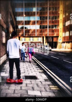 Uomo che cavalca una ruota gemellata auto-equilibratura di scooter elettrici, Harrow-su-il-Hill, London Borough di Harrow, a nord ovest di Londra, Inghilterra, Regno Unito, Europa Foto Stock