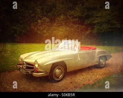 Un argento vintage Mercedes Benz 190 SL decorate convertibile per un matrimonio in un giardino Foto Stock